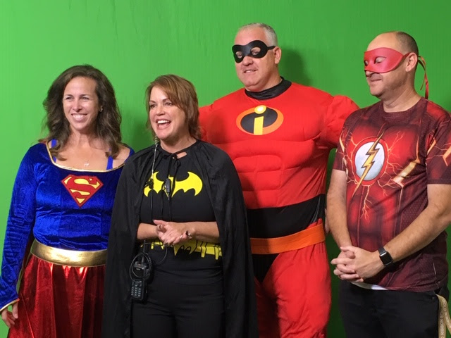 Ms. Surfas (lft.) and Dr. Hodgson (3rd from left) appearing on the announcements in costume in 2019.