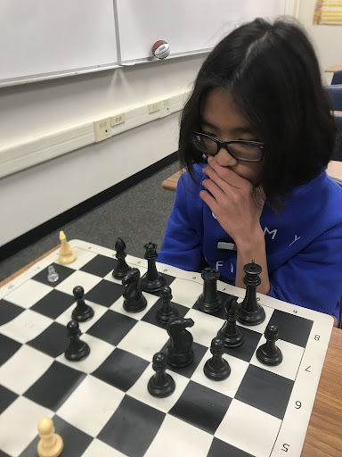 Chess club member Minh Nguyen (9th) strategizes on which chess piece to move next. (Photo credit to: Jonathon Rice)