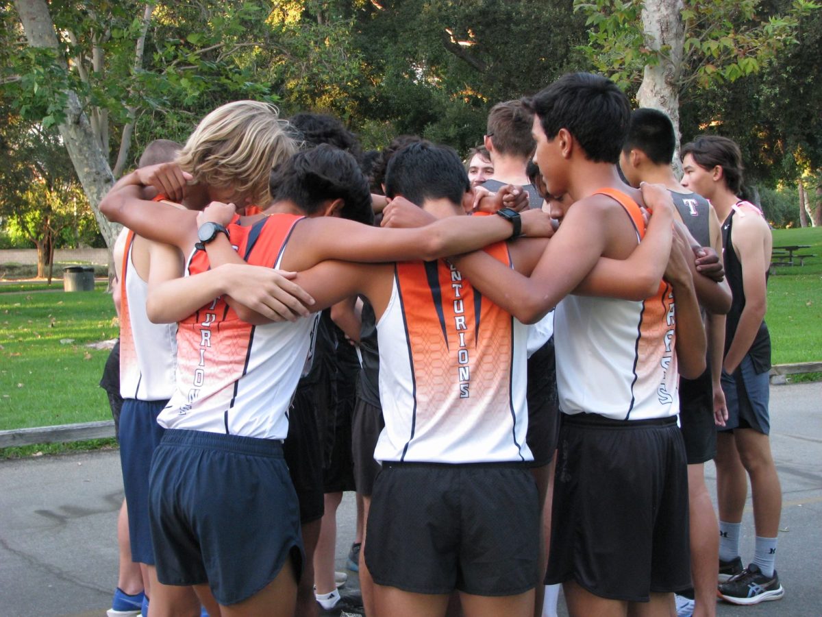 Cypress Cross-Country runners huddle up for motivation before the race starts.