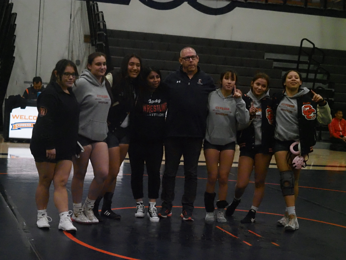 Girls Wrestling team smiling wide, celebrating seniors on their senior night.